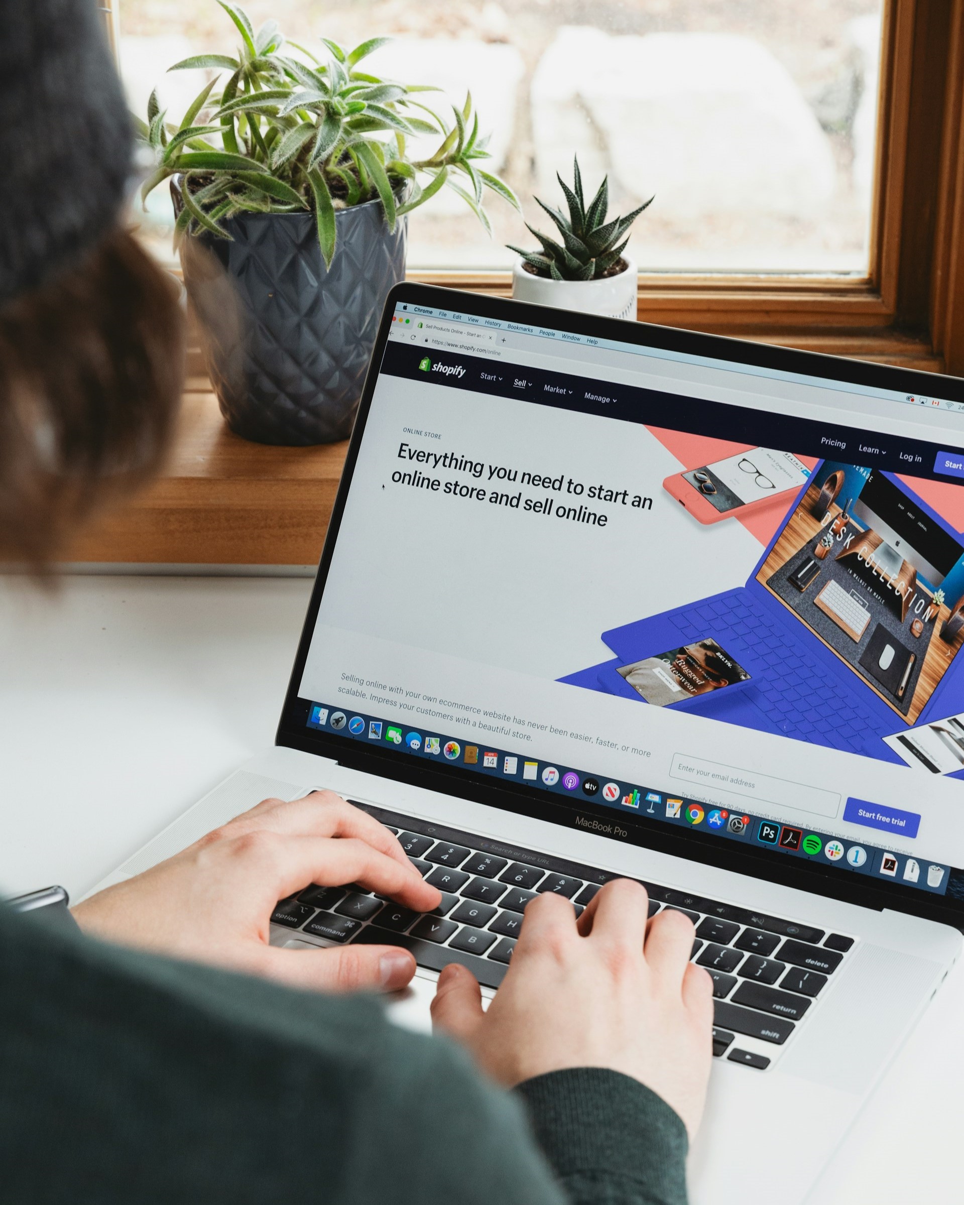 Person sitting in front of a laptop working on an e-commerce website